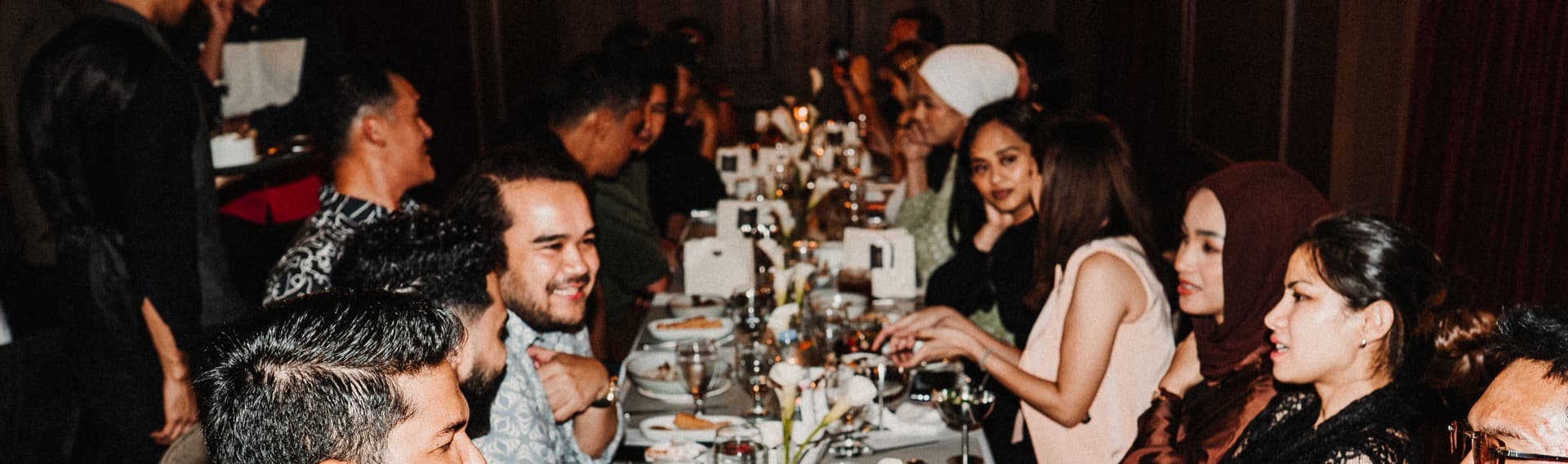 Guests sharing dinner at a long table in a JIBRIL dining room.